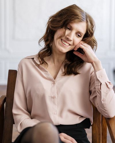 Professional wellness coach Sofia Kravchuk smiling in a warm amber lighting